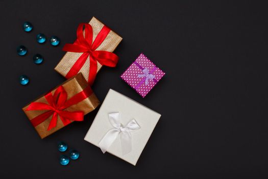 Gift boxes with ribbons on black background.