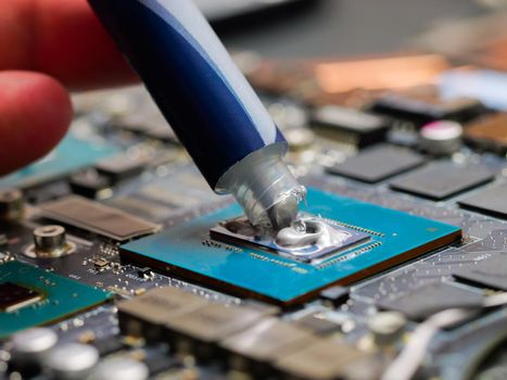 Technician squeezing the fresh thermal paste compound