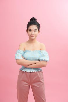 Portrait of charming girl folded arms isolated over pink pastel color background