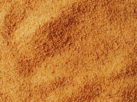 Background texture of raw organic coconut sugar from crystallized sap of cut flower buds coconut palm. Brown coconut palm sugar background topview. Alternative healthier low glycemic index sweetener