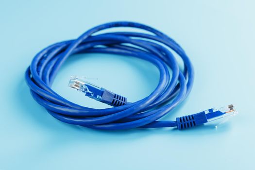 A coil of an Internet network cable for data transmission on a blue background