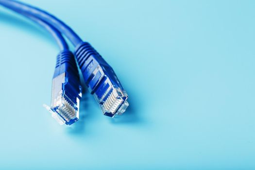 Ethernet Cable connector Patch cord cord close-up on a blue background with free space