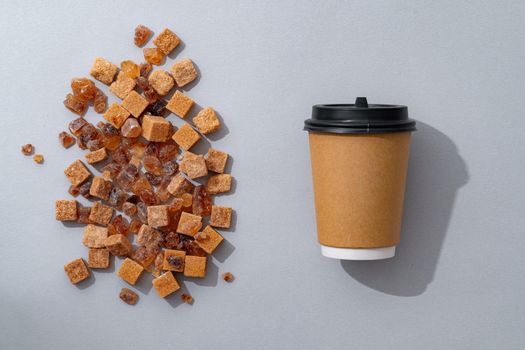 Cup of coffee with brown sugar on gray background