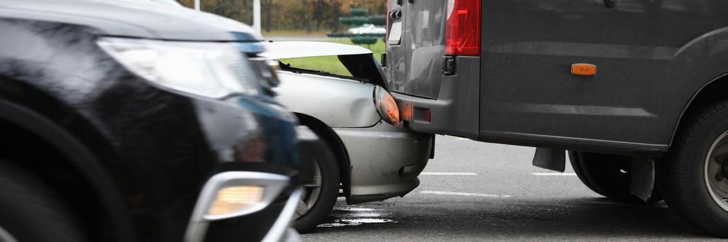 Car and blue minivan crash on road closeup