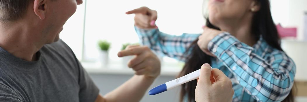 Man and woman communicating with pregnancy test in hands