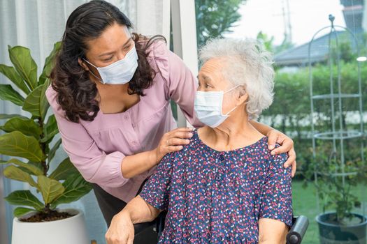Caregiver help Asian senior or elderly old lady woman sitting on wheelchair and wearing a face mask for protect safety infection Covid19 Coronavirus.