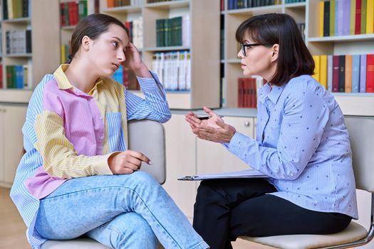 Psychologist, high school behavior counseling teenage student in library