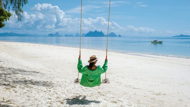 woman on the beach of the tropical Island Naka Island near Phuket Thailand, woman at a swing on the beach