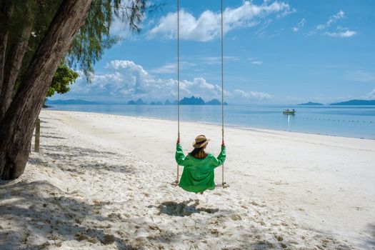 woman on the beach of the tropical Island Naka Island near Phuket Thailand, woman at a swing on the beach
