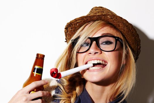 Youre never too old to enjoy party favors. A gorgeous young woman with a party favor in her mouth holding a beer.