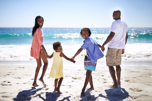 The ocean looks amazing. An african-american family enjoying a day at the beach together.