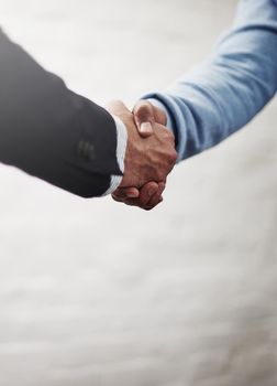 Its amazing what we can achieve when we come together. Cropped shot of two businesspeople shaking hands.