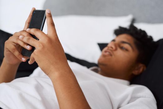 There are pages and pages full of fun websites. Shot of a young man using his cellphone while lying on his bed.