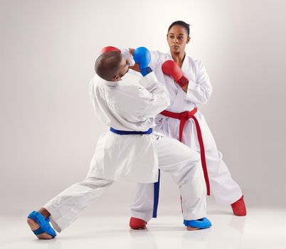 Avoiding her punches. Two people doing karate.