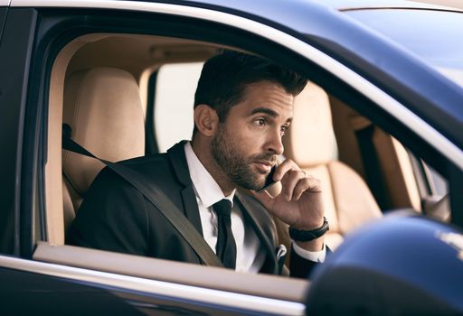 Im headed into the office right now. Cropped shot of a handsome young businessman making a phonecall while on his morning commute to work.