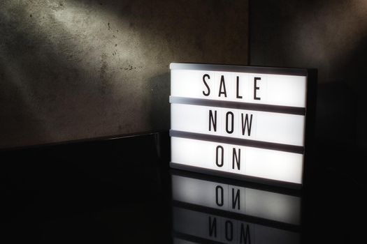 Sale now on message on a light box with a dark cinematic feel