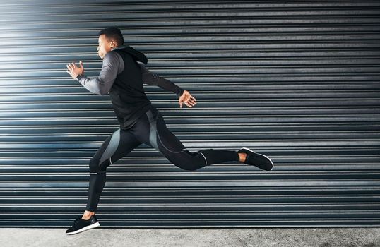 You havent failed until you quit trying. Shot of a sporty young man running against a grey background.
