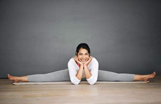 Yoga is the best way to start the day. Portrait of an attractive young woman doing the splits in her yoga routine.