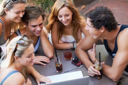 Look at this. Group of teens enjoying beverages while at an outdoor restaurant with all their modern technology.