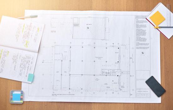 The workspace of an architect. High angle shot of blueprints on a desk.