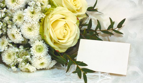 Bouquet of white and yellow flowers with an empty greeting card