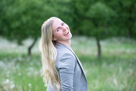 Happy 30 year old blond woman beautifully smiling. Plain cheerful girl in the park