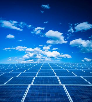 Blue photovoltaic solar panel horizon background with sky and clouds