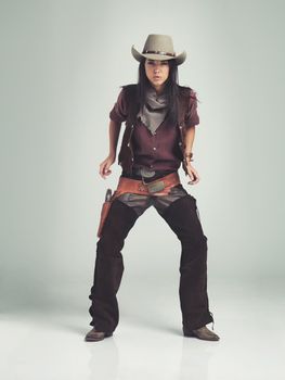 Im the sheriff around these parts.... Full-length shot of an attractive young woman in cowboy attire.