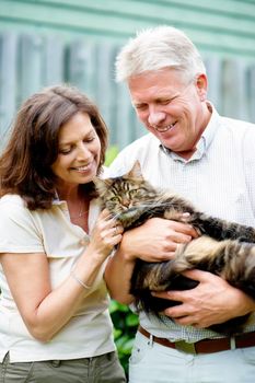 Hes like a member of the family. Cropped shot of a senior couple with their cat outdoors.