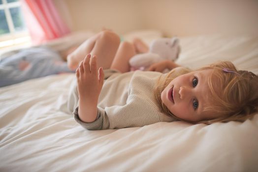 So much sweetness from one little girl. Portrait of an adorable little girl relaxing on the bed at home.