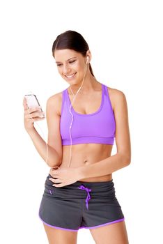 Tunes to workout with.... Shot of a sporty young women listing to music on an mp3 player isolated on white.