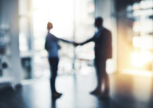Opportunity is always out there. Defocused shot of two businesspeople shaking hands in an office.