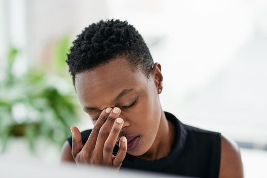 Work stress, the struggle is real. Shot of a young businesswoman experiencing stress at work.