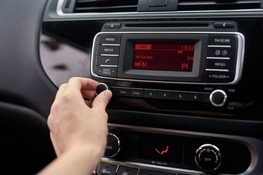 Tuning the stereo. Closeup shot of a driver tuning a car radio.