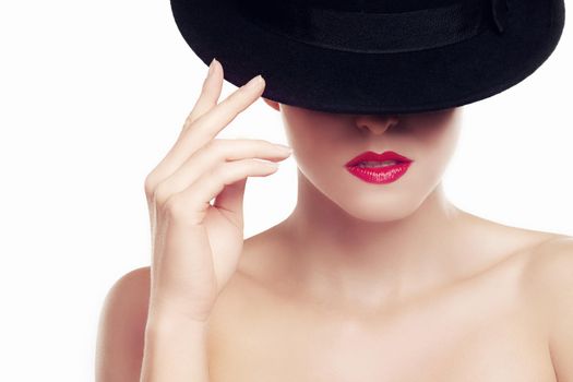 Bold style. Beauty shot of a young woman wearing a hat and red lipstick.