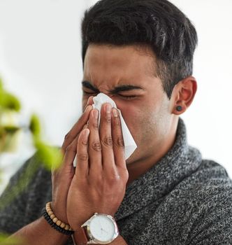 Its flu season. Cropped shot of a young man suffering with allergies.