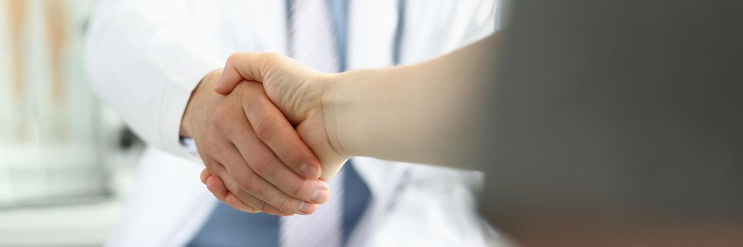 Doctor and patient shaking hands, grateful person