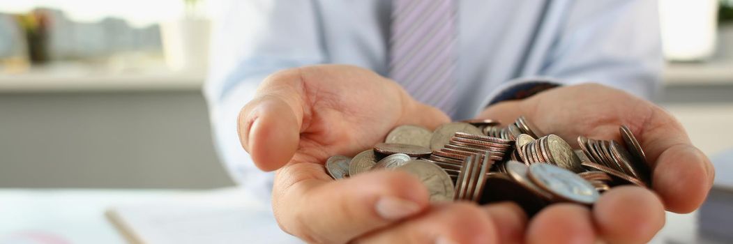 A man in the office holds coins in his palms