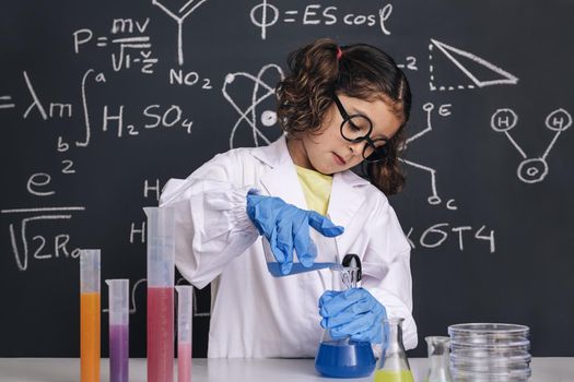 little scientist with gloves mixing chemicals