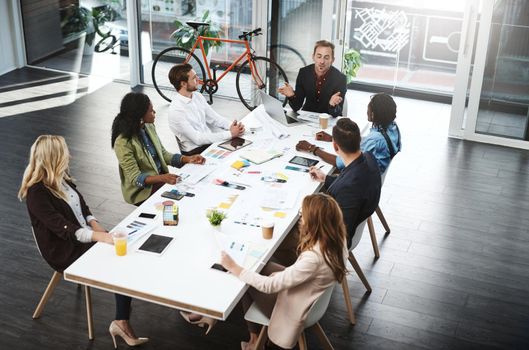 Engaging with bold ideas around the table. Shot of a group of businesspeople having a meeting in a boardroom.