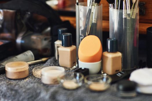 Tools of the beauty trade. Shot of a numerous amount of different types of makeup laid out on top of a table.