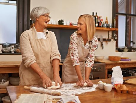 Learning grandmas secret recipes. A grandmother teaching her granddaughter how to bake.