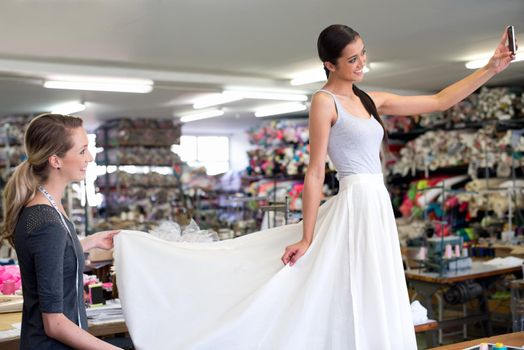 Beautiful Its exactly what I wanted. A young woman in a fabric shop trying on a skirt made for her by a seamstress.
