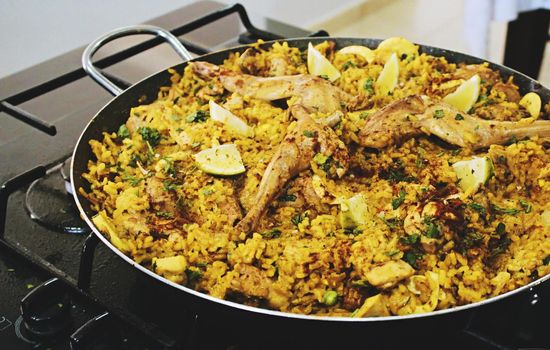 A big shallow pan dish containing paella with rice and meat