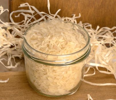 rice groats in a glass jar stands on a wooden surface against