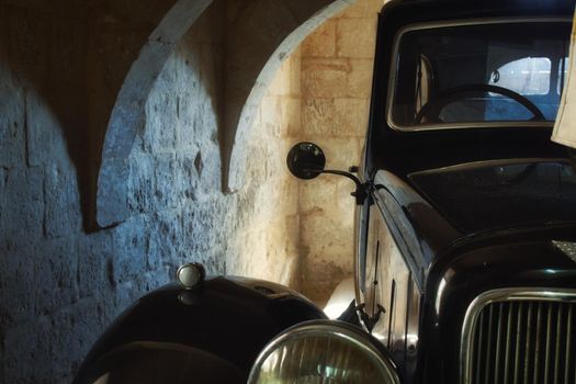 Classic car stored in a basement with stone walls