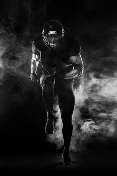 Sport concept. American football sportsman player on black background. Sport concept.