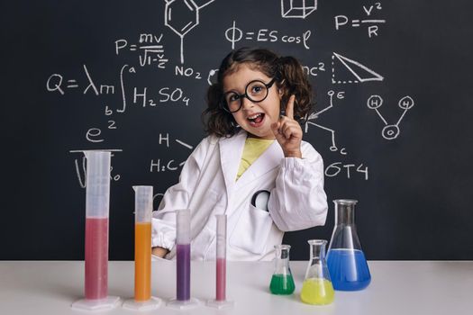 funny scientist child in lab coat having an idea