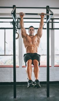 Aim high. Shot of a muscular man working out in a gym.