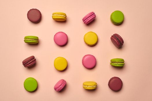 Colored macaron or macaroon, sweet meringue-based confection on pink background. Close-up, copy space.